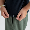 Amo tricou din lână merinos pentru copii; auro-kid-s-fleece-pants-459836-size-banner-large-v-2*: Doi copii în tricou și pantaloni din fleece stau spate în spate, unul dintre ei cu o placă de skateboard